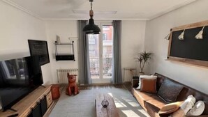 Una sala de estar con sofá, mesa de centro, televisor y chimenea.