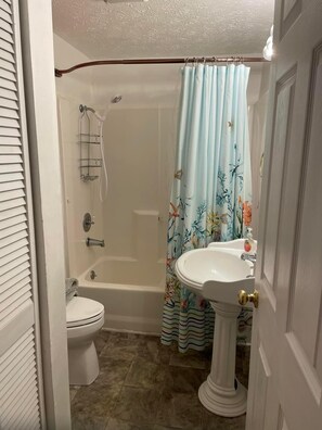 A bathroom with a toilet, bathtub, and sink.