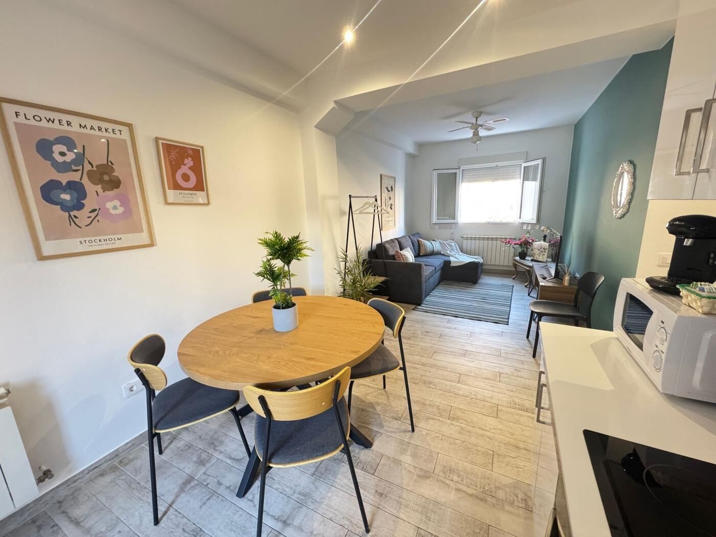 Un espacio de estar moderno con comedor, sofá, cafetera y radiador.