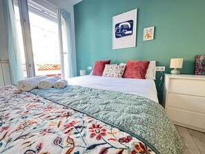 A hotel room with a bed, a window, a wall with artwork, and a nightstand. - La Terraza de Manzanera (Logroño)