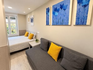 Ein Schlafzimmer mit Bett, Sofa und Fenster.