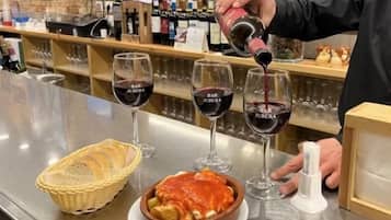 A bar setting with wine glasses, a basket, and a dish of food.