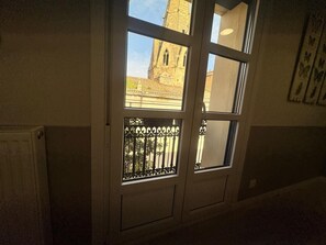 Una finestra amb vista a un edifici amb una torre.