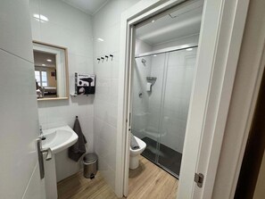 A bathroom with a sink, toilet, and shower. - APARTAMENTOS SAN NICOLAS (LOGROÑO)