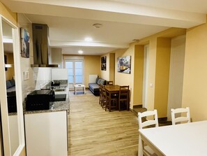 Un espacio habitable compacto con kitchenette, comedor y sofá.