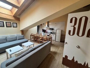 A loft-style apartment with a dining area, kitchenette, and a large window. - APARTAMENTOS SAN NICOLAS (LOGROÑO)