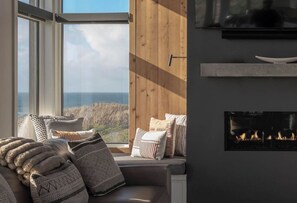 A cozy room with a large window, a fireplace, and a view of the outdoors.