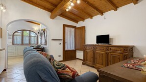 Un soggiorno con un divano, un armadio in legno e un televisore.