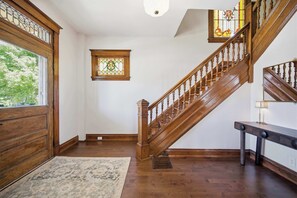 A wooden staircase with a stained glass window above it. - Hillside Hyde Park Home 4bdr (Cincinnati)