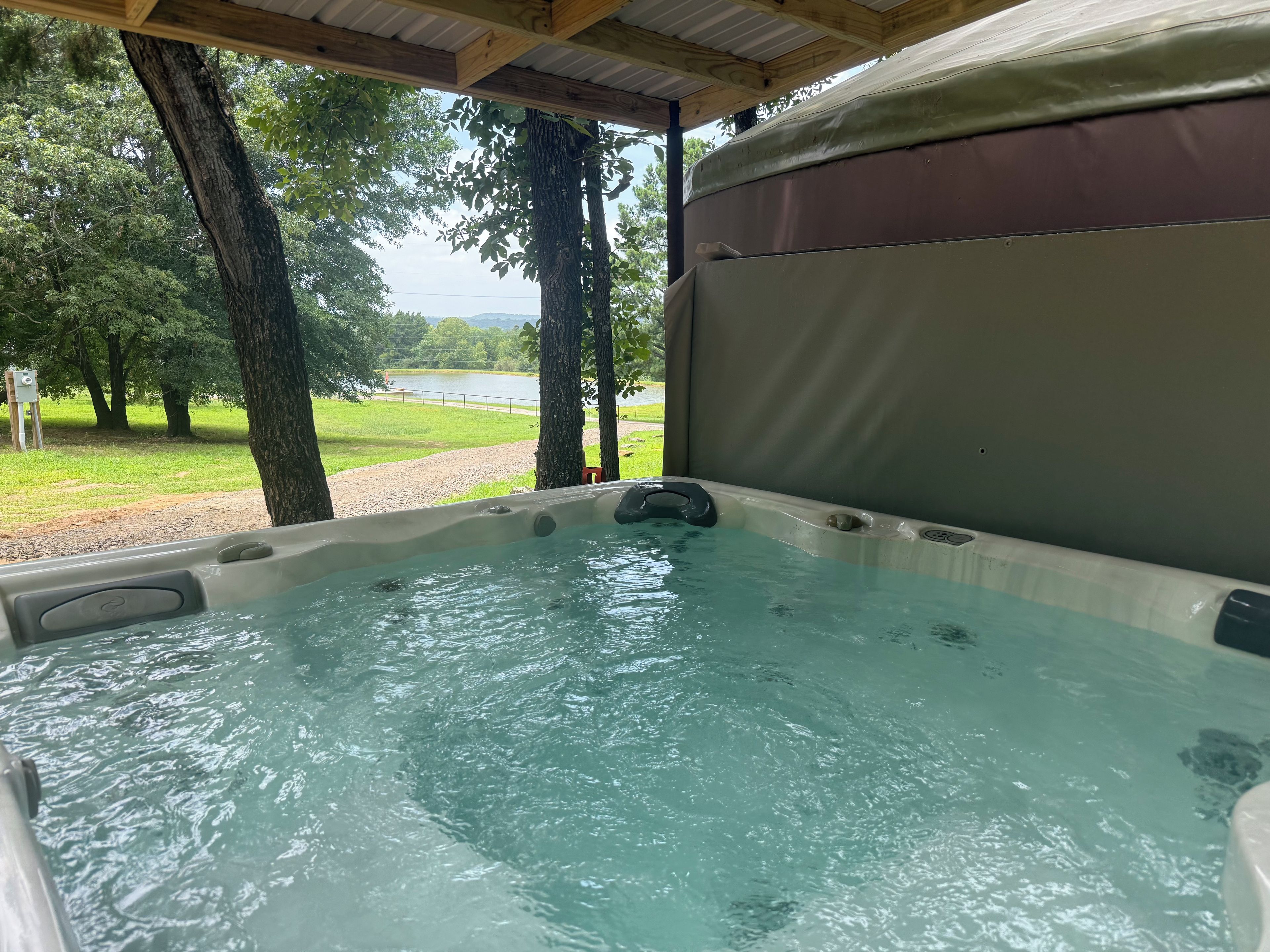 Ein Whirlpool mit Blick auf einen See und Bäume.
