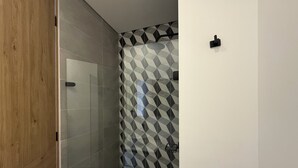 Un bagno con doccia, pareti piastrellate e porta in legno.