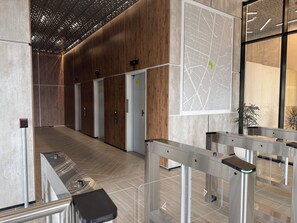 Eine moderne Lobby mit Holzvertäfelung, einer Karte an der Wand und einer Drehscheibe am Eingang.