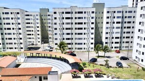 A multi-story hotel with a swimming pool, outdoor seating, and a parking area. - Apartment in Plaza Teste (Parnamirim)