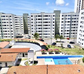 Ein mehrstöckiges Hotel mit Schwimmbad, Außenbereich und Parkplatz.
