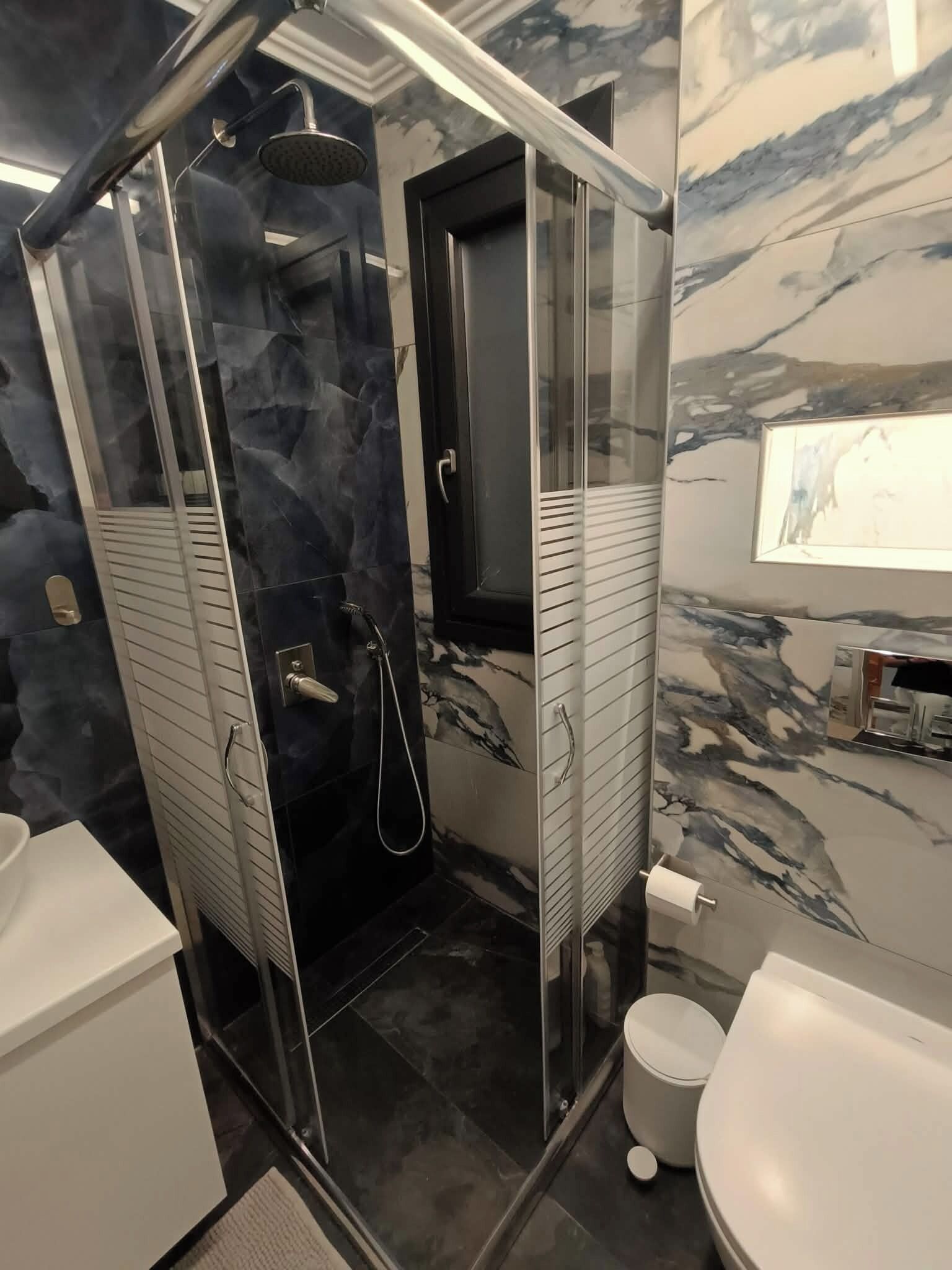Ein modernes Badezimmer mit Duschkabine, Toilette und Waschbecken.