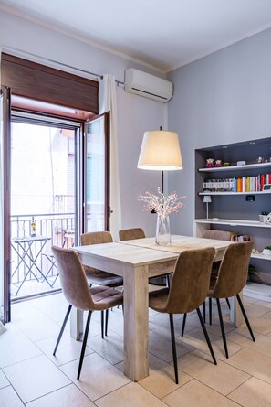 Ein Essbereich mit Tisch, Stühlen, einer Lampe und einem Bücherregal.