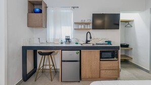 A compact kitchen with a refrigerator, microwave, coffee maker, and a small sink. - Loft con entrada 24/7 | Check-in autónomo (Monterrey)