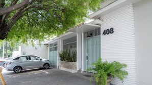 Ein Gebäude mit der Nummer 408, ein Auto vor der Tür und ein Blumentopf neben dem Eingang.