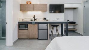 A compact kitchen with a microwave, refrigerator, and a flat-screen TV above the counter. - Loft a 15 min de Fundidora | Mundial 2026 (Monterrey)