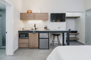 A compact kitchen with a microwave, refrigerator, and a flat-screen TV above the counter. - Loft a 15 min de Fundidora | Mundial 2026 (Monterrey)