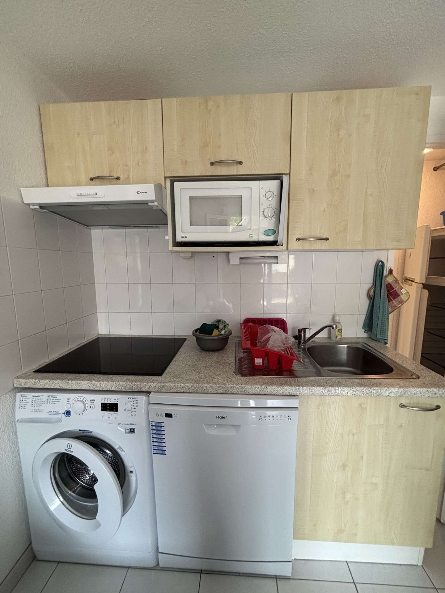 A compact kitchen with a microwave, a dishwasher, and a washing machine.