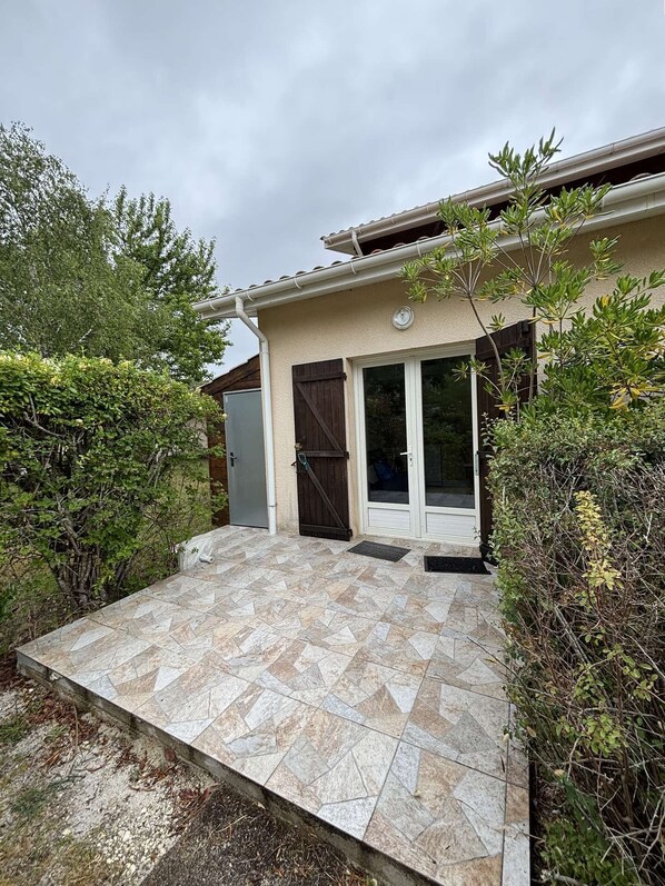 A house with a tiled patio, a door, and a window.