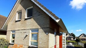 A residential building with a gabled roof, multiple windows, and a visible address number. - Dijkhuis Sauna 6 (Medemblik)