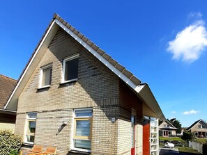 Ein Wohngebäude mit Giebeldach, zahlreichen Fenstern und einer gut sichtbaren Hausnummer.