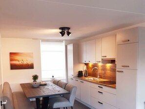 Eine moderne Küche mit weißen Schränken, einer Holz Arbeitsplatte und einer eingebauten Spüle.
