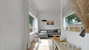 A modern living room with a sofa, a coffee table, and a lamp. - Chic Bespoke 4BR Home: King Beds&Fully Fenced Bkyd (Clarington)