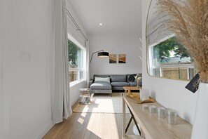 Un salon moderne avec un canapé, une table basse et une lampe.