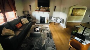 A living room with a sofa, coffee table, fireplace, and two chairs. - This is the Pittsburgh View-Mt. Washington Skyline Escape! (Pittsburgh)