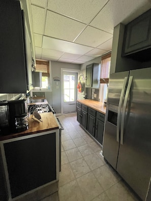 A kitchen with a stove, refrigerator, and wooden countertop. - This is the Pittsburgh View-Mt. Washington Skyline Escape! (Pittsburgh)