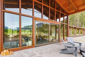 A modern building with large glass windows, a wooden ceiling, and outdoor seating. - Elsie's Hut: Mazama Cabin with Big Mountain Views (Mazama)