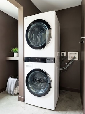 A wall-mounted washer and dryer unit with a control panel and power cord. - Industrial Loft · Walk to Westport · Sleeps 6 (Kansas City)