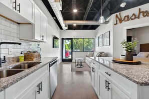 Eine moderne Küche mit weißen Schränken, Granit Arbeitsplatten und einem sichtbaren Namensschild.
