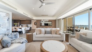 Ein modernes Wohnzimmer mit einer Couch, einem Couchtisch und einem Essbereich mit Stühlen.