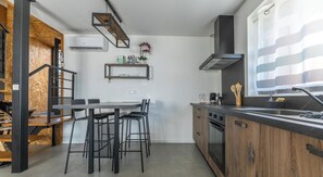 Eine moderne Küche mit Essbereich, Holzelementen und einem eingebauten Backofen.