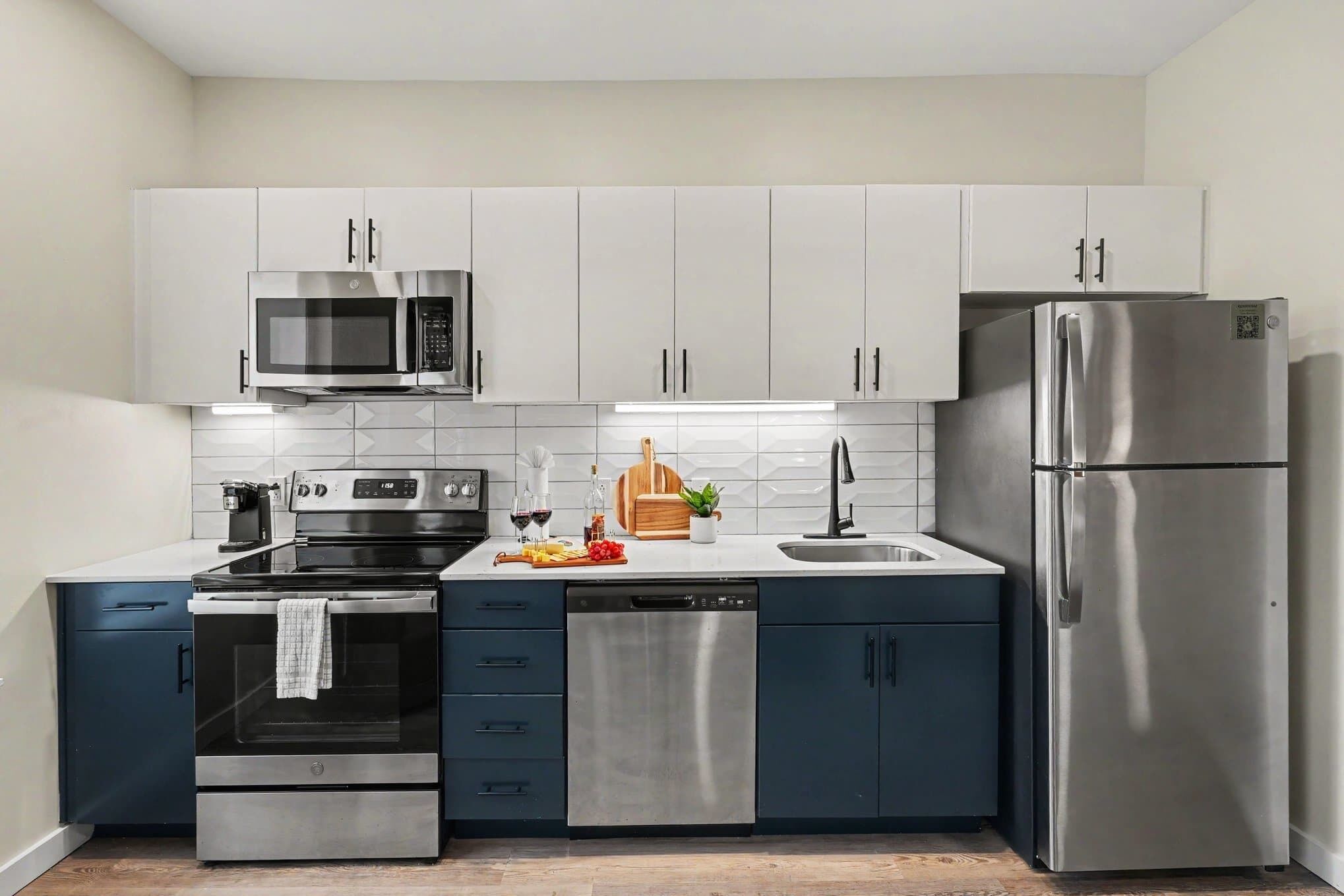 A modern kitchen with stainless steel appliances, including a microwave, oven, dishwasher, and refrigerator.