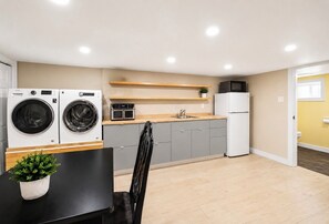 Cocina compacta con lavadora, microondas y refrigerador.