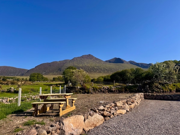 A picnic table in a rural setting with mountains in the background.