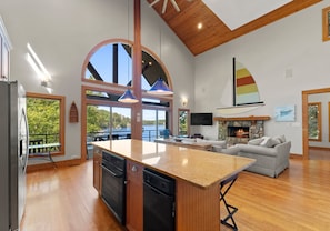 A modern kitchen with a central island, a dining area with a view, and a cozy seating area with a fireplace. - Mi Casa, Su Casa | Fire Pit | Dock | Game Rom | Sleeps 14 (Sherrills Ford)