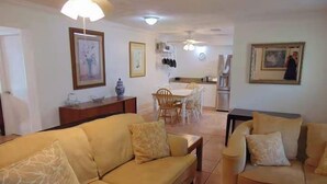 Una sala de estar con un sofá, una mesa de centro y un comedor con sillas y una mesa.
