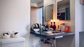 A modern bathroom with a stainless steel sink, a mirror, and a toilet. - Massive Loft Penthouse w best views in Prime DTLA (Los Angeles)