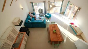 Quarto com sofá, mesa, cadeira e janela.