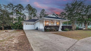 A single-story house with a garage, a covered porch, and a well-maintained lawn. - The Pinewood · Dog-Friendly 30A Home for 8 (Santa Rosa Beach)