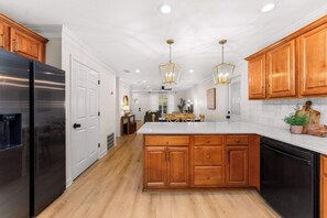 A modern kitchen with wooden cabinets, a stainless steel refrigerator, and a central island. - Dog-Friendly 30A Home | Sleeps 8 | Fire Pit Yard (Santa Rosa Beach)