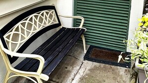 A bench outside a door, a potted plant, and a window with plants. - Private Escazú Studio Chill Pad (Escazu)
