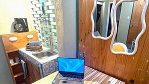 A small kitchenette with a laptop, a coffee maker, and a sink. - Private Escazú Studio Chill Pad (Escazu)