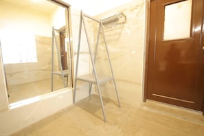 A bathroom with a marble wall, a wooden door, and a metal ladder. - Premium Dome With Hill and River Viewhotel Ribera (Dehradun)